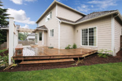 A wooden deck built in a backyard of a modern home