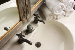 Repurposed rustic mirror used in a modern bathroom
